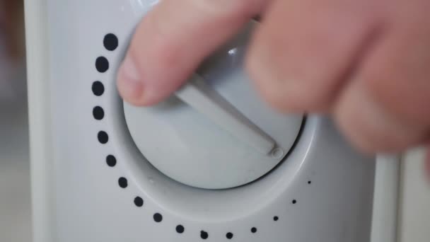 L'uomo avvia un riscaldatore elettrico portatile riscaldando una cella frigorifera da casa — Video Stock