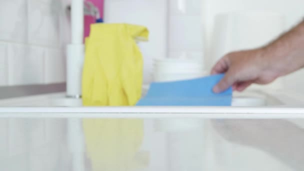 Man neemt gele huishoudelijke handschoenen en natte doekjes op de gootsteen voor te bereiden om te beginnen met schoonmaken in de keuken — Stockvideo