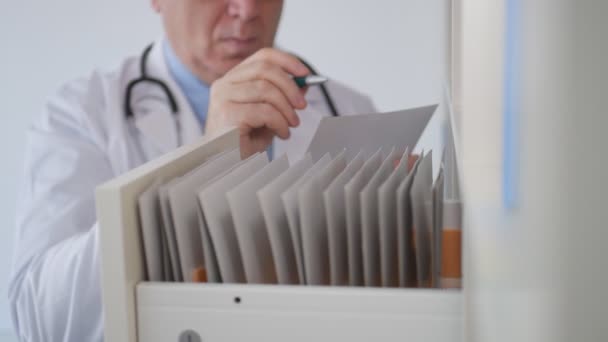 Slow Motion with a Doctor Completing a Medical Record and Putting Back to a Drawer from Hospital Archive — Stock Video