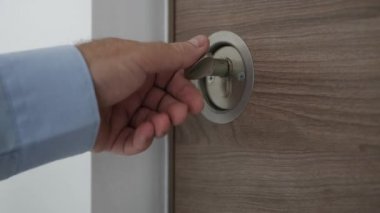 İşadamı, ofisine girişteki metal kapıyı açar ve açar.