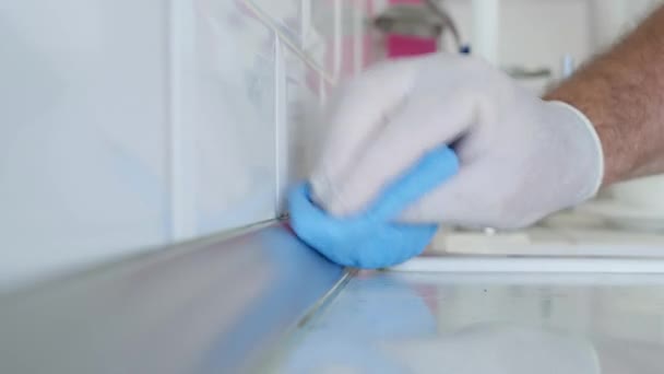 Un homme avec des gants de protection nettoie et désinfecte la cuisine et la salle de bain — Video