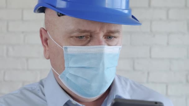 Інженер з безпечним шолом і захисна маска на обличчі Розмовляє по телефону — стокове відео