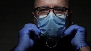 Bir Solunum Hastalığında Tıbbi Danışmanlık için stetoskop kullanarak COVID-19 'a karşı Yüz Maskesi ve Koruma Eldiveni ile Korunan Doktor
