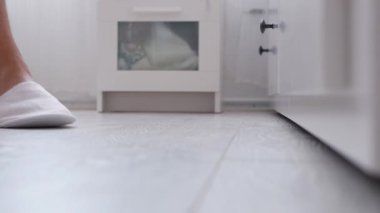 Yatak odasında terlik giyen yaşlı bir insanın ayakları.