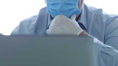 Maske ve Koruyucu Eldiven Giyen Doktor Laptop İletişim kullanıyor