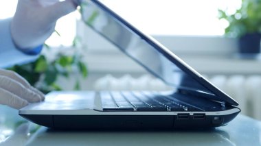 Dizüstü bilgisayarın tuş takımını kullanarak Koruyucu Eldiven Giyen Eldivenli Resmi Kapat