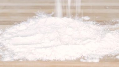 Baker bir fırında ekmek için hamur hazırlarken masaya beyaz un koydu.