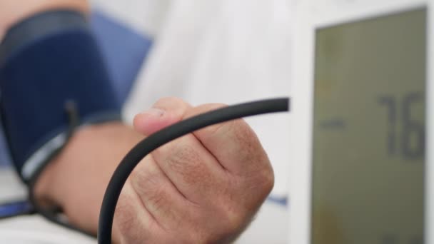 Médico toma a pressão arterial do paciente usando um dispositivo eletrônico moderno com um display digital — Vídeo de Stock