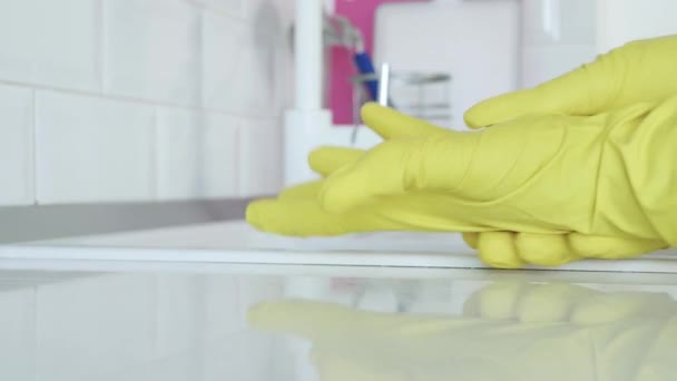 Muž si dává své žluté ochranné rukavice na ruce připravuje začít úklid v kuchyni — Stock video