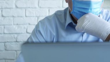 Maske ve Koruyucu Eldiven Giyen Doktor Laptop İletişim kullanıyor