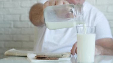 Bir Kişi Gazete Oku ve Bir Kadehi Kahvaltı İçin Taze Sütle Doldur, Lezzetli ve Vitamin Sütüyle Doldur