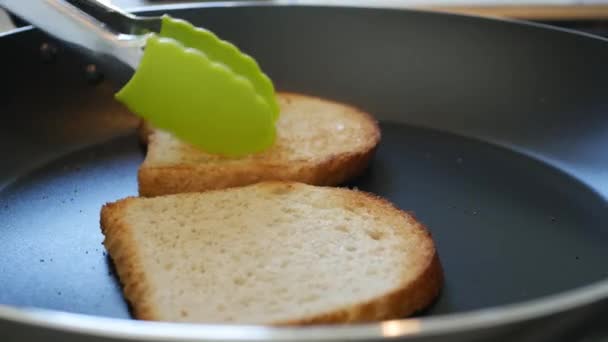 Dos rebanadas de pan tostado cocinado en una sartén en la estufa — Vídeo de stock