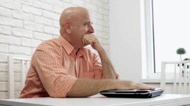 Dizüstü bilgisayar kullanan üzgün ve hayal kırıklığına uğramış bir iş adamı resmi