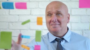 İş Adamı Gülümsemesi Toplantı Odasında Renkli Yapışkan Notlarla Saydam Bir Yönetim Kurulu Arkasında Memnun Oldu