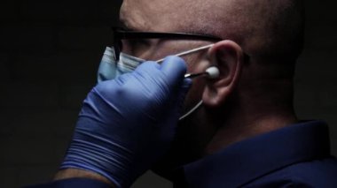 Bir Solunum Hastalığında Tıbbi Danışmanlık için stetoskop kullanarak COVID-19 'a karşı Yüz Maskesi ve Koruma Eldiveni ile Korunan Doktor