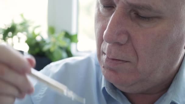 Ο άνθρωπος που έχει τα συμπτώματα Coronavirus λαμβάνοντας θερμοκρασία του σώματος του σε ένα νοσοκομείο χρησιμοποιώντας ένα θερμόμετρο με κλίμακα υδραργύρου — Αρχείο Βίντεο