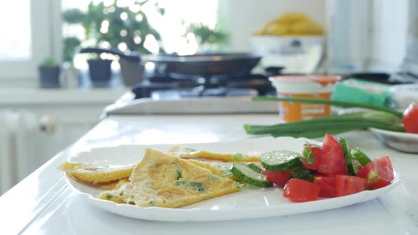 Горячая яичница с овощным салатом на тарелке на кухне — стоковое видео