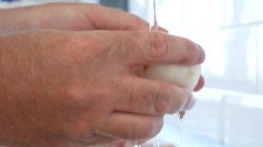 Taze ve lezzetli bir mantarı musluktan temiz suyla yıkamak.