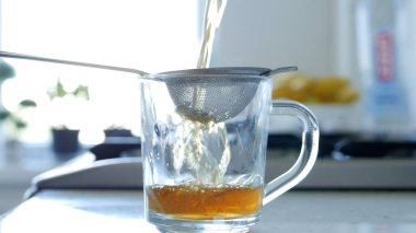 Bir Süzgeç ve Doğal Çay Yaprakları Kullanarak Sıcak ve Aromatik Çay Yaparken Görüntü