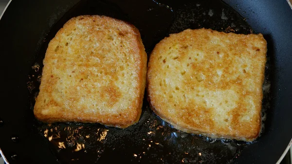 Man Cooking French Eggs Toast in a Hot Pan for a Delicious Breakfast