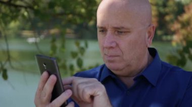 Parkta Smartphone 'da Mesajlaşan ve Gülümseyen Mutlu Adam' ın Portresi