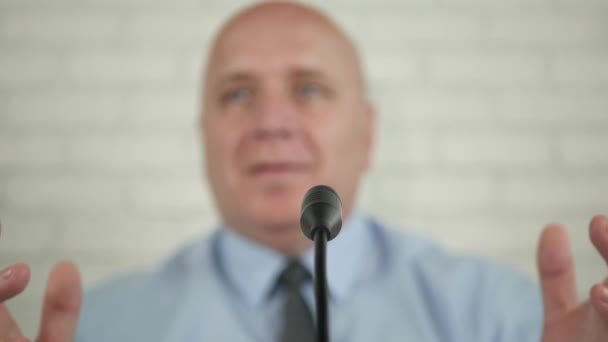 Suddig bild av en politiker i en presskonferens talar vid mikrofon och Gesturing — Stockvideo