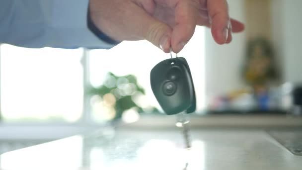 La mano de un hombre poniendo algunas llaves del coche con control remoto en la mesa — Vídeo de stock