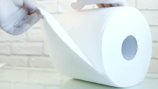Verpleegster met beschermende handschoenen in handen neemt droge papieren handdoeken uit een rol met behulp van ze voor het reinigen — Stockvideo