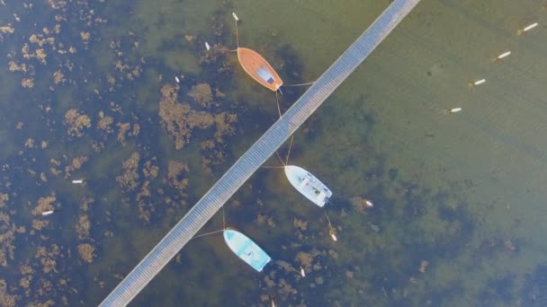 Luchtfoto spinnen weergave van een houten pier met bijgevoegde boten — Stockvideo