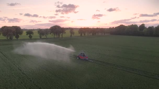 Drohnenbild: Wasserwerfer steht bei Sonnenuntergang auf einem Feld — Stockvideo