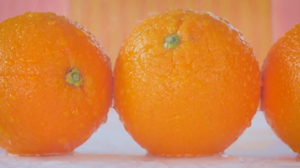 Deslizamiento a lo largo de naranjas donde el agua está rociando sobre ellos — Vídeos de Stock