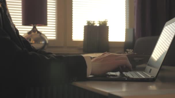 Empresario trabaja en un ordenador portátil y mira el reloj — Vídeos de Stock