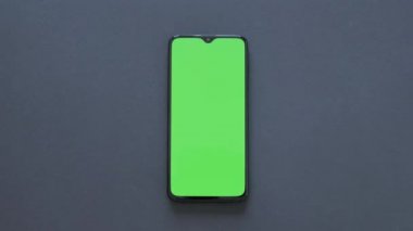 Yeşil Ekran - Modern bir akıllı telefon siyah arka plan üzerinde yatıyor