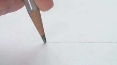 Kağıt üzerinde tahta kalemle düz bir çizgi çizen sanatçıların yakın çekim.