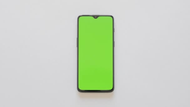 Pantalla verde - Un teléfono inteligente moderno se encuentra en el fondo blanco — Vídeos de Stock