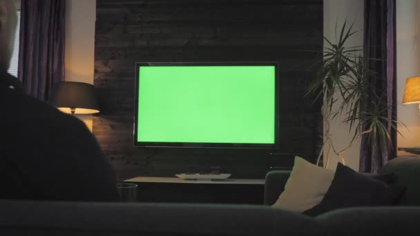 Πράσινη οθόνη-άνθρωπος βλέποντας τηλεόραση στο σαλόνι. Πάνω από το σουτ του ώμου. — Αρχείο Βίντεο