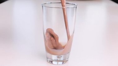 içme bardağına çikolatalı süt dökme