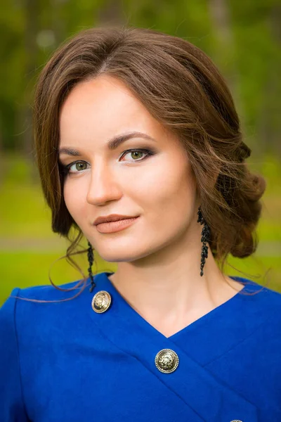 Close-up portret van bruinharig meisje in een blauwe jurk met make — Stockfoto