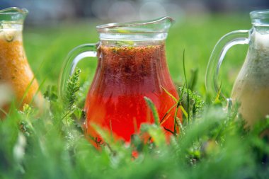 Çilekli limonata, cam sürahide güneşli bir çimenlikte. 