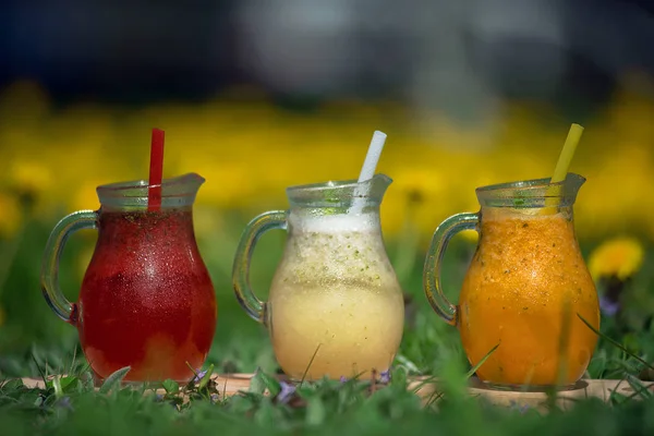 Cam sürahide farklı renkte limonata ve pipet.