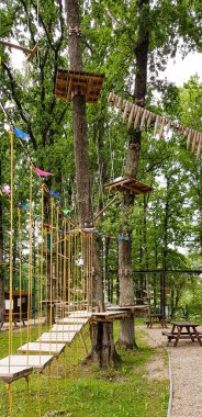 Yaz ormanı manzaralı mavi gökyüzü manzaralı bir halat macera parkı..