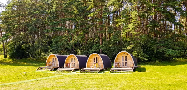 Tiny house or hotel pod made from wood in form of covered wagon.