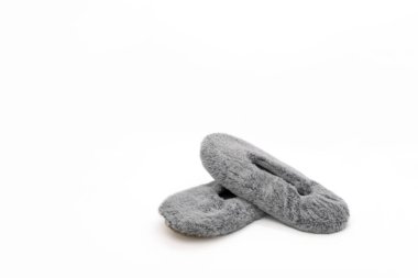 Beyaz arka planda izole edilmiş tüylü gri ev terlikleri. Yatak ayakkabısı, aksesuar ayakkabı..