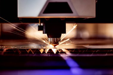 Otomatik programlanmış makine. Endüstriyel lazer makinesi çelik levha parçalarını kesiyor. Sıcaklık. Fabrikadaki üretim makinesinin çalışması sırasında kıvılcımlar.
