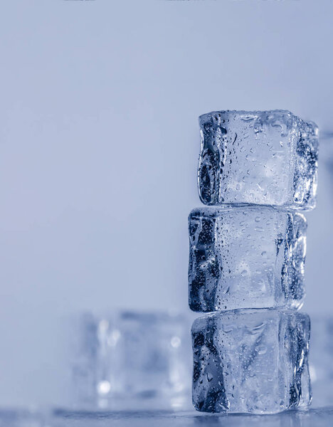 Ice cubes covered with drops of water stand on top of each other. Frozen water in form of a cube, ice. Critically pure ice.