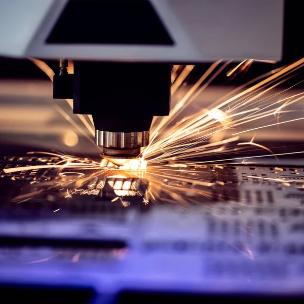 Otomatik programlanmış makine. Endüstriyel lazer makinesi çelik levha parçalarını kesiyor. Sıcaklık. Fabrikadaki üretim makinesinin çalışması sırasında kıvılcımlar.