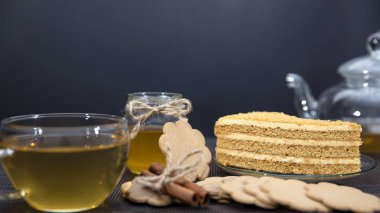 Tatlım pasta yalanlar üzerine bir daire. Yeşil çay bir fincan ve çaydanlık.