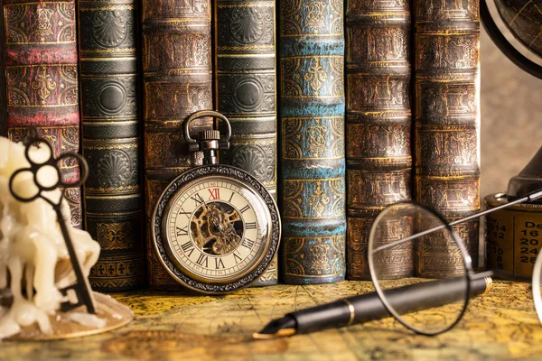 Antika saat arka planda bir mum ile bir anahtar ve Kitaplar. Vintage tarzı. 1565 yıl eski Haritası.