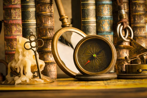 Antika pusula bir mum bir anahtar ve Kitaplar ile arka plan üzerinde. Vintage tarzı. 1565 yıl eski Haritası.