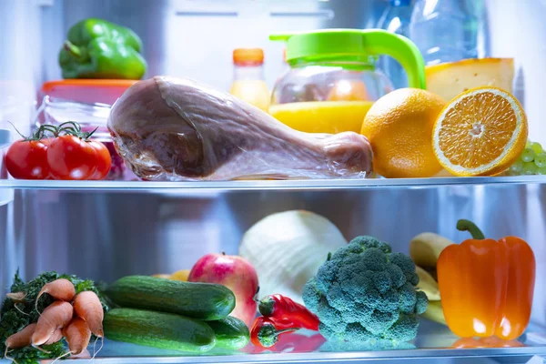 Open fridge. Turkey drumstick Fresh vegetables and fruits. Fresh juice.